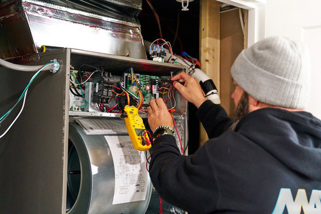 Mays tech repairing a furnace